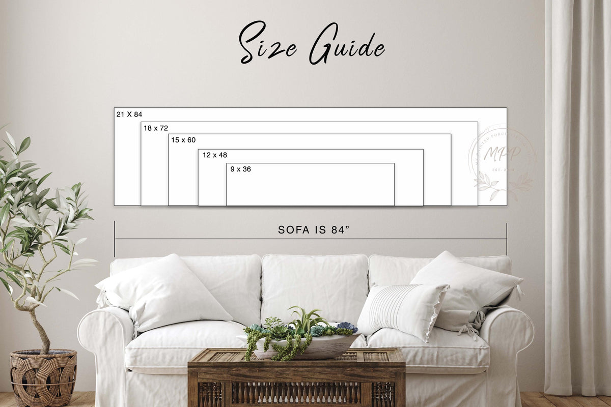 a living room with a white sofa and a wooden coffee table. Above the sofa, there is a size guide that provides dimensions for the different sizes of the sofa.